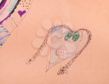 girl's head with pigtails shaped as heart hand drawn by colour pens on brown paper