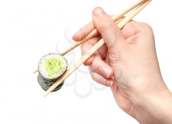 female hand with disposable chopsticks holds kappa maki sushi roll with cucumber isolated on white background