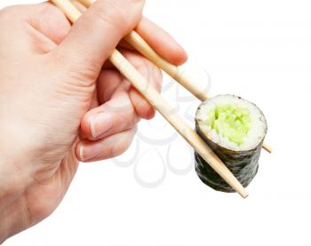 female hand with disposable chopsticks holds kappa maki sushi roll with cucumber close up isolated on white background
