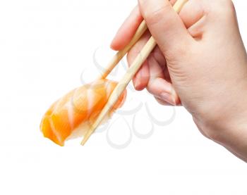 female hand with disposable chopsticks holds sake nigiri sushi with salmon fish isolated on white background
