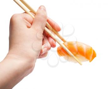 female hand with wooden chopsticks holds sake nigiri sushi with salmon fish isolated on white background