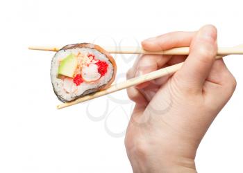 female hand with disposable chopsticks holds western-style sushi roll close up isolated on white background