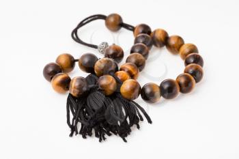 tangled worry beads from tiger's eye gemstones on white paper background