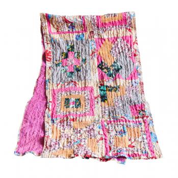 folded stitched patchwork scarf from various silk strips and crushed pink cotton fabric isolated on white background
