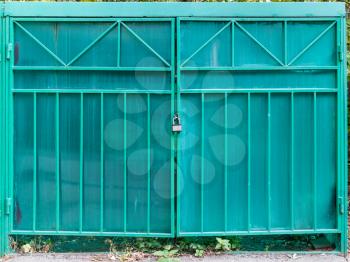 front view of closed doors of outdoor garage made from green translucent honeycomb polycarbonate panels