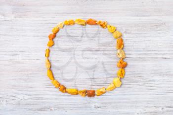 top view of raw amber necklace on gray wooden board with copyspace