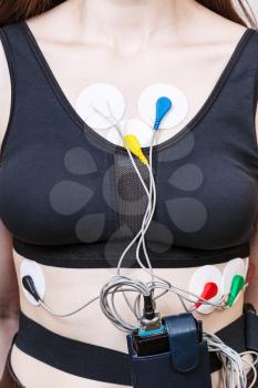 sensors and recorder of Holter monitor for electrocardiogram are attached to female body
