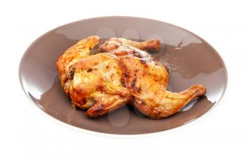roasted whole flattened chicken on brown plate isolated on white background