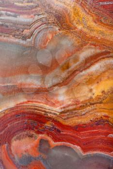 brown background from polished natural banded Calcite Onyx rock (onyx marble, Limestone Onyx) close up