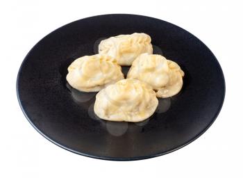 cooked Manti (type of dumpling in turkic cuisine) on black plate isolated on white background