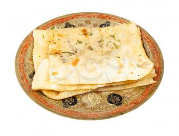 Indian cuisine - garlic naan (garlicky flatbread) on brass plate isolated on white background
