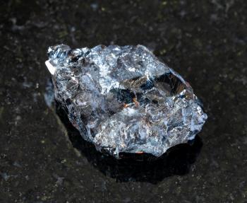closeup of sample of natural mineral from geological collection - unpolished Sphalerite (zink blende) rock on black granite background from Dalnegorsk, Primorye, Russia