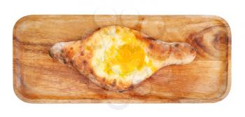 georgian cuisine - top view of Adjarian khachapuri with egg on wooden tray isolated on white background