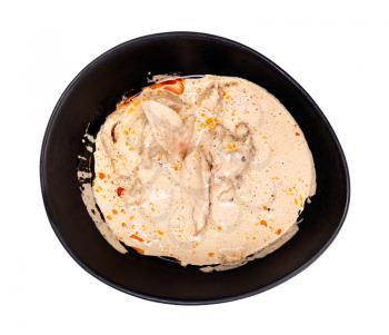 georgian cuisine - top view of Satsivi (spicy cold appetizer from poultry in walnut sauce) in black bowl isolated on white background