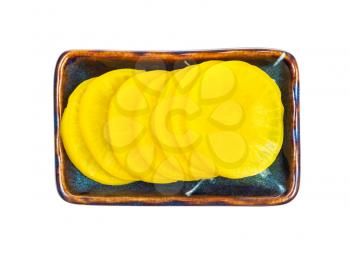 top view of traditional korean and japanese Takuan (Danmuji) side dish from pickled daikon radish in ceramic bowl isolated on white background