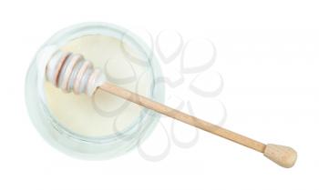 top view of wooden stick over glass jar with natural organic white honey isolated on white background