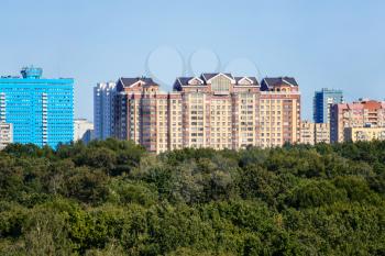 above view of lush green city park and rhigh-rise apartment houses on horizon on sunny September day in Moscow city