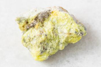 closeup of sample of natural mineral from geological collection - rough native Sulphur (Sulfur) rock on white marble background from Vodinskoye deposit, Samara region, Russia
