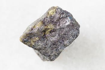 closeup of sample of natural mineral from geological collection - rough Bornite with Chalcopyrite rock on white marble background from Azerbaijan