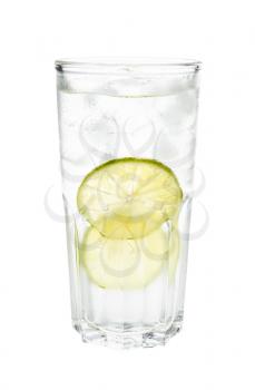 side view of gin and tonic cocktail in highball glass with two slices of lime and ice isolated on white background