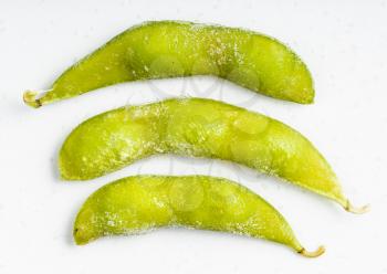 several frozen Edamame (unripe soybeans) pods close up on gray ceramic plate