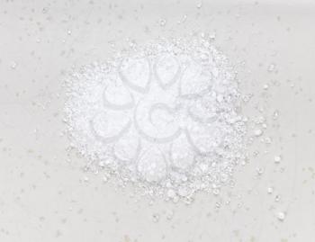 top view of pile of crystalline citric acid close up on gray ceramic plate