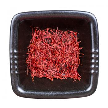 top view of crocus saffron threads in black bowl isolated on white background