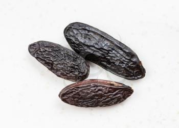 few dried tonka beans close up on gray ceramic plate
