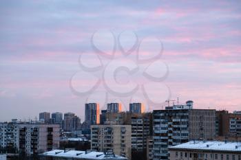 pink clouds in blue sky over residential district in Moscow city at dusk