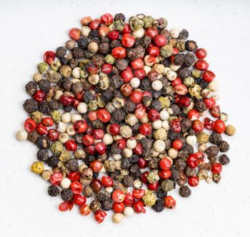 top view of pile of Four Pepper Blend peppercorns close up on gray ceramic plate