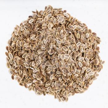 top view of pile of dried dill seeds close up on gray ceramic plate
