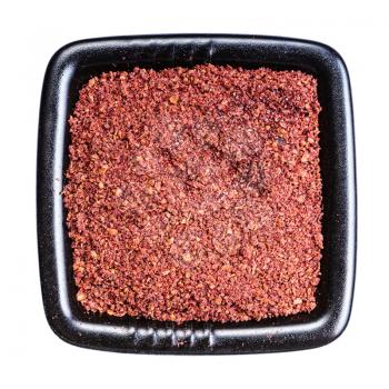 top view of ground sumac spice in black bowl isolated on white background
