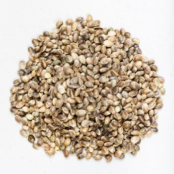 top view of pile of unpeeled hemp seeds close up on gray ceramic plate