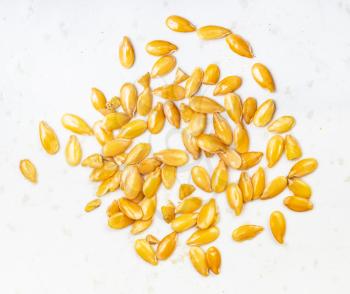 several golden flax seeds close up on gray ceramic plate