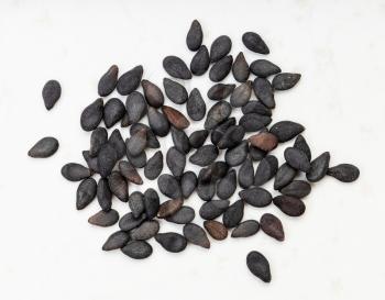 several black sesame seeds close up on gray ceramic plate