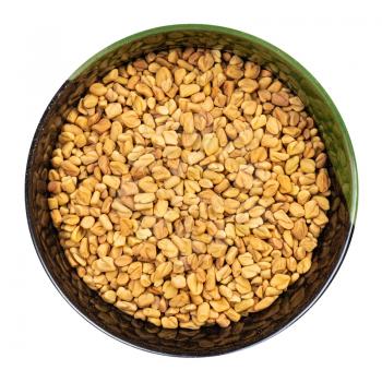 top view of whole fenugreek seeds in round bowl isolated on white background