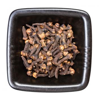 top view of whole dried cloves in black bowl isolated on white background