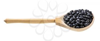 wooden spoon with uncooked black mexico beans isolated on white background