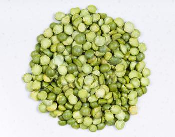 top view of pile of raw dried green split peas close up on gray ceramic plate