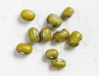 several raw green mung beans close up on gray ceramic plate