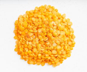 top view of pile of raw split red lentils close up on gray ceramic plate