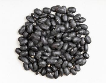 top view of pile of raw black turtle beans close up on gray ceramic plate