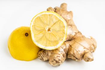 natural fresh whole ginger root and halved lemon fruit on gray plate close up