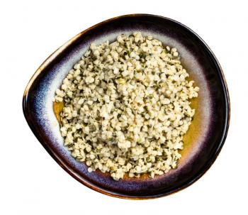 top view of cores of hemp seeds in ceramic bowl isolated on white background