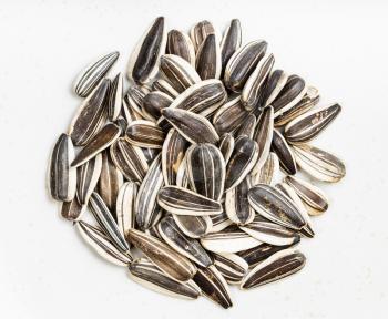 top view of pile of whole sunflower seeds on gray ceramic plate