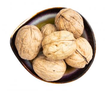 top view of whole walnuts in ceramic bowl isolated on white background