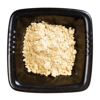 top view of ginger powder in black bowl isolated on white background