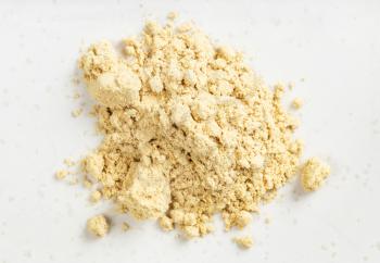 top view of pile of ginger powder close up on gray ceramic plate