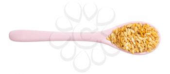top view of ceramic spoon with golden flax seeds isolated on white background
