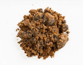 top view of pile of dark muscovado cane sugar close up on gray ceramic plate